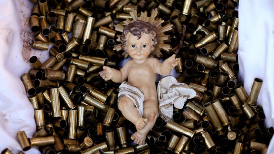 A statue of the baby Jesus on a bed of bullet shells is seen in a Nativity scene outside the Basilica of St Francis in Assisi